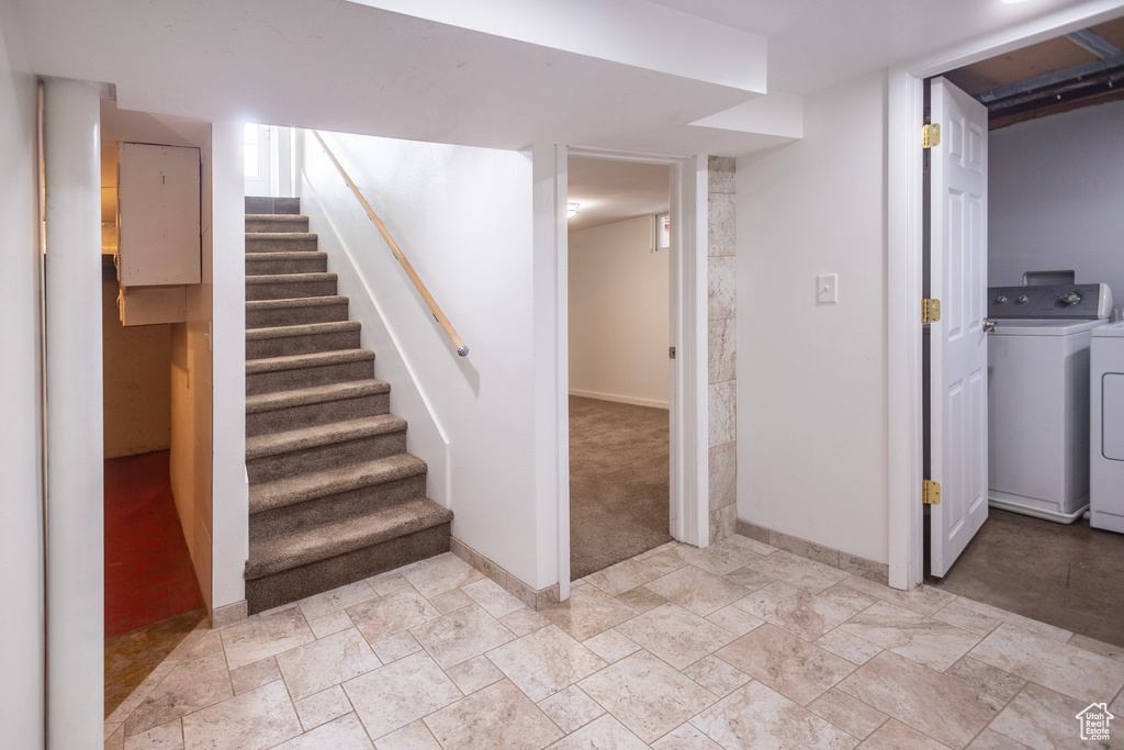 Staircase featuring washing machine and dryer, baseboards, and stone finish floors