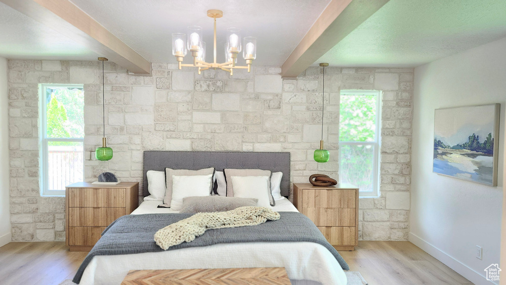 Bedroom with beam ceiling, a chandelier, light wood-style floors, and baseboards