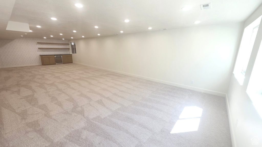 Unfurnished living room featuring light carpet, baseboards, and recessed lighting