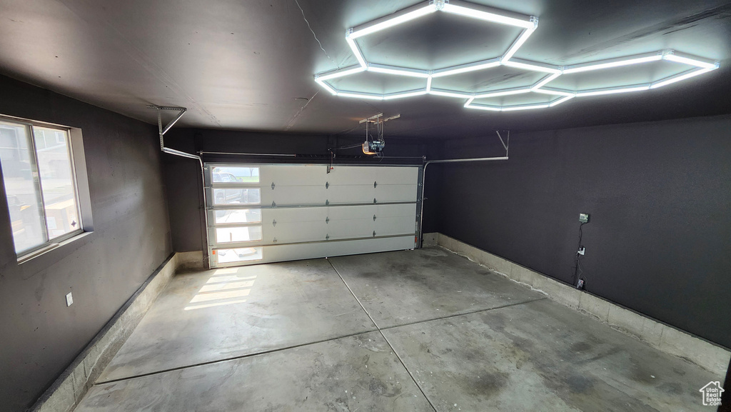 Garage with a garage door opener and baseboards