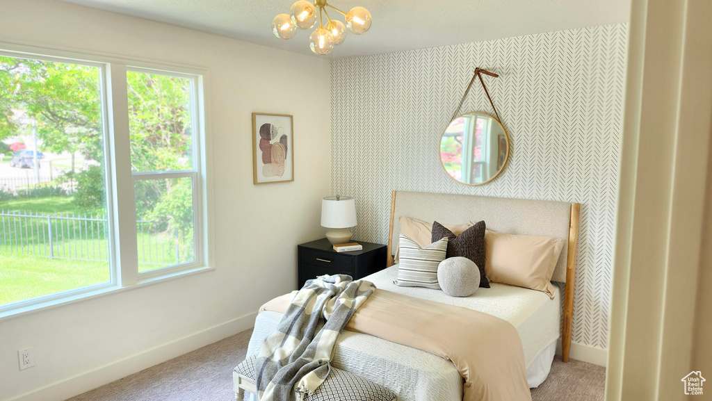 Bedroom with carpet, baseboards, multiple windows, and a chandelier