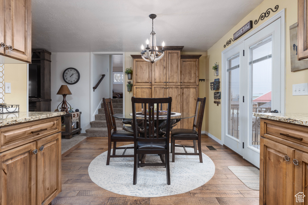 Dining room with a chandelier, dark wood-style floors, stairway, and baseboards