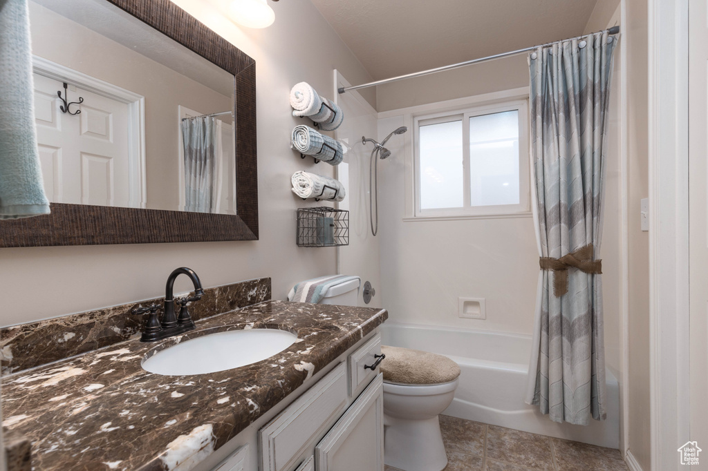 Full bath featuring shower / bath combination with curtain, vanity, toilet, and tile patterned floors