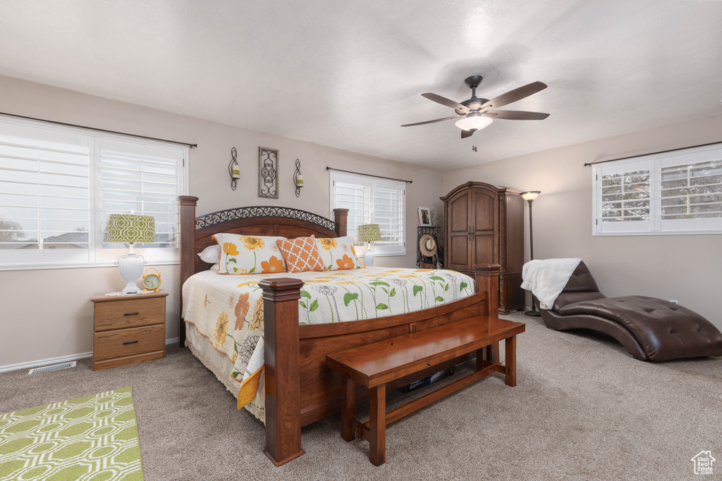 Bedroom with light colored carpet and a ceiling fan