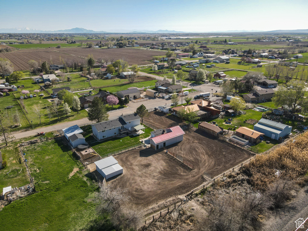 Aerial view of property and surrounding area featuring rural landscape and a mountain backdrop