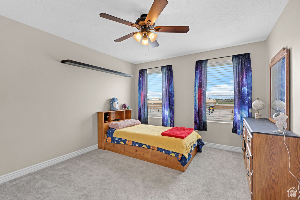 Bedroom with carpet, baseboards, and a ceiling fan
