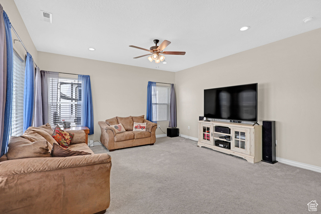 Living area with ceiling fan, carpet floors, baseboards, and recessed lighting