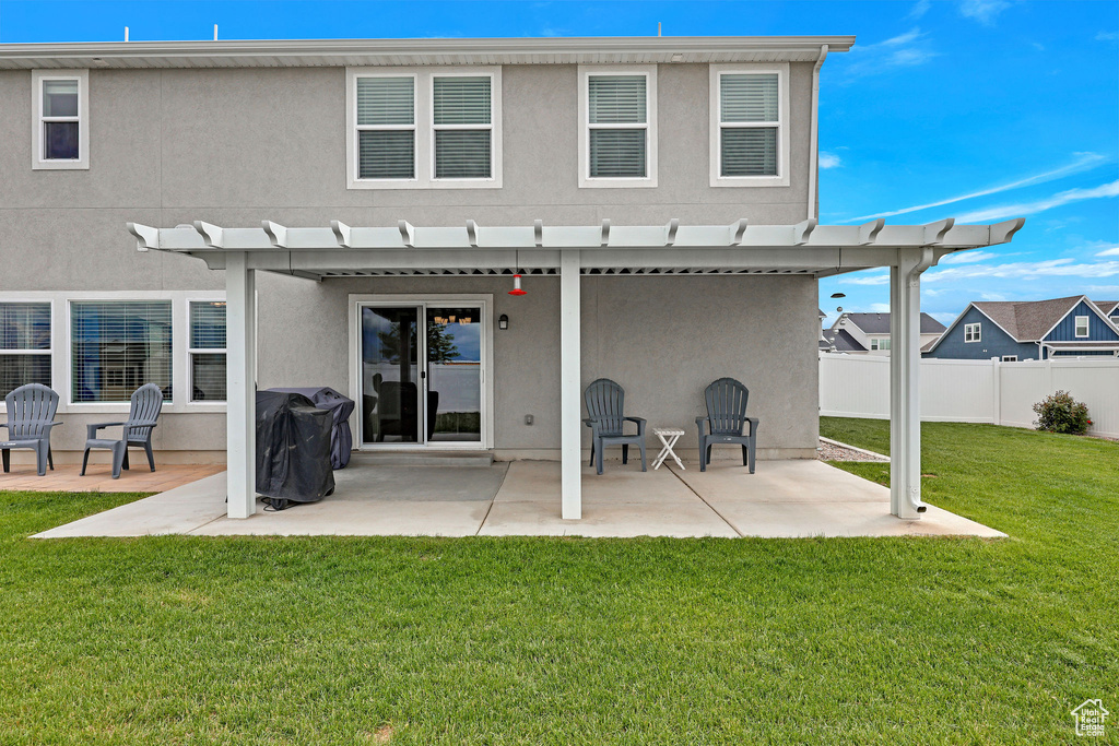Back of property with stucco siding, a patio, and a pergola