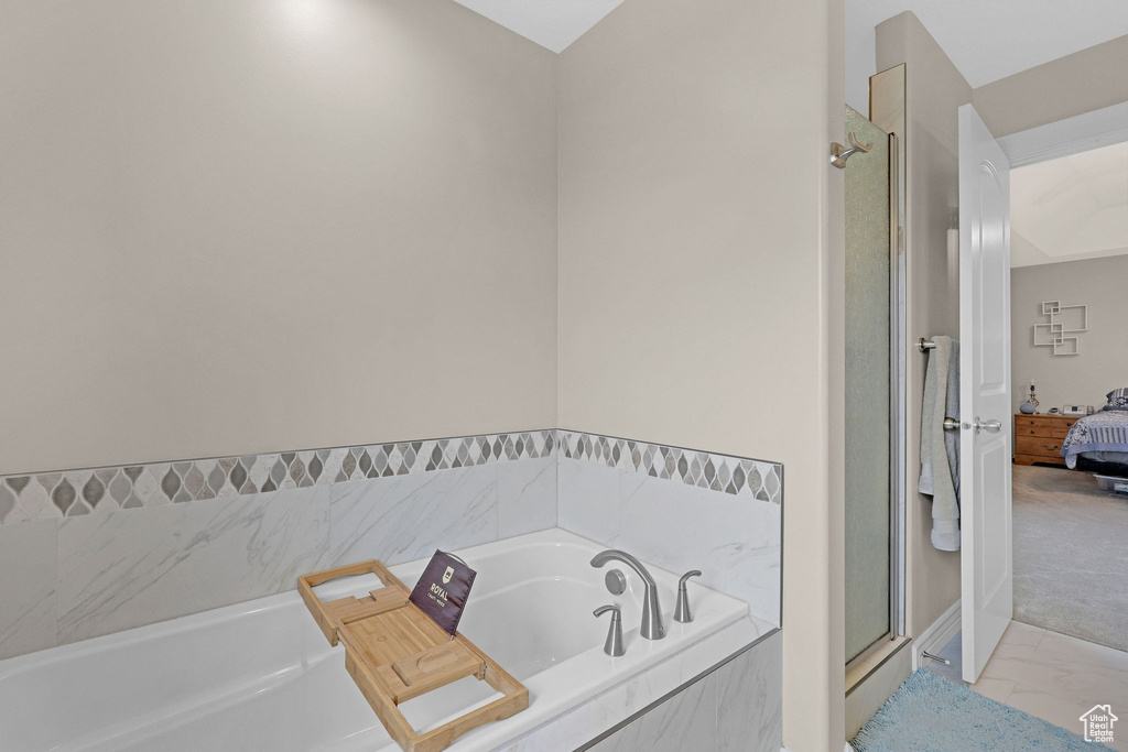 Bathroom featuring a stall shower, ensuite bathroom, marble finish flooring, and a garden tub
