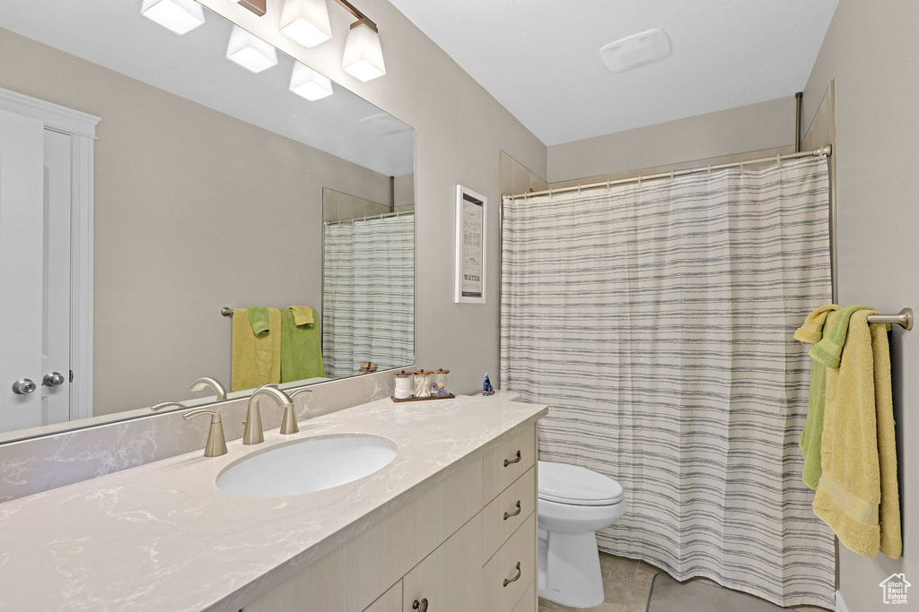 Full bathroom featuring toilet, vanity, tile patterned flooring, and a shower with curtain