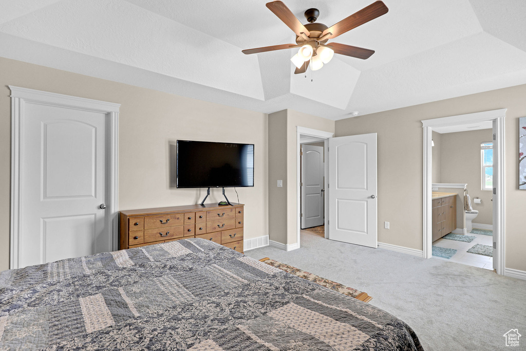 Bedroom featuring light carpet, baseboards, ensuite bath, and a ceiling fan