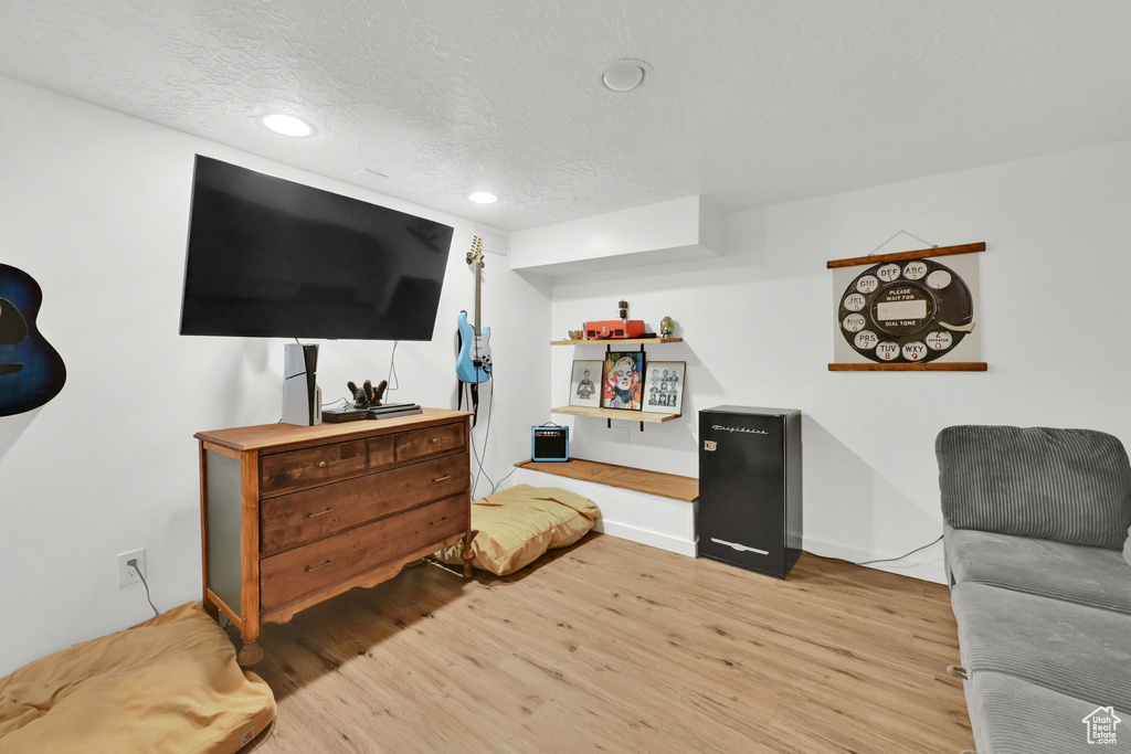 Living area with light wood-style floors, recessed lighting, and baseboards