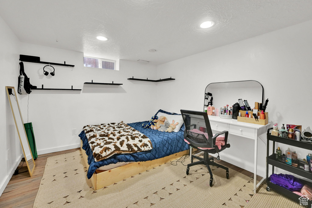 Bedroom featuring wood finished floors, baseboards, and recessed lighting