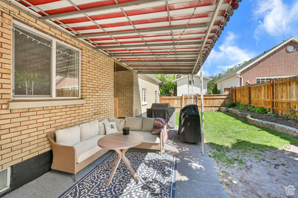 Fenced backyard featuring an outdoor living space and a grill