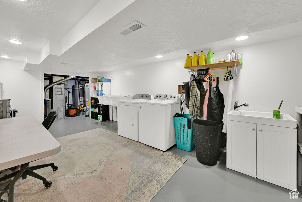 Finished basement with separate washer and dryer, recessed lighting, a textured ceiling, and gas water heater