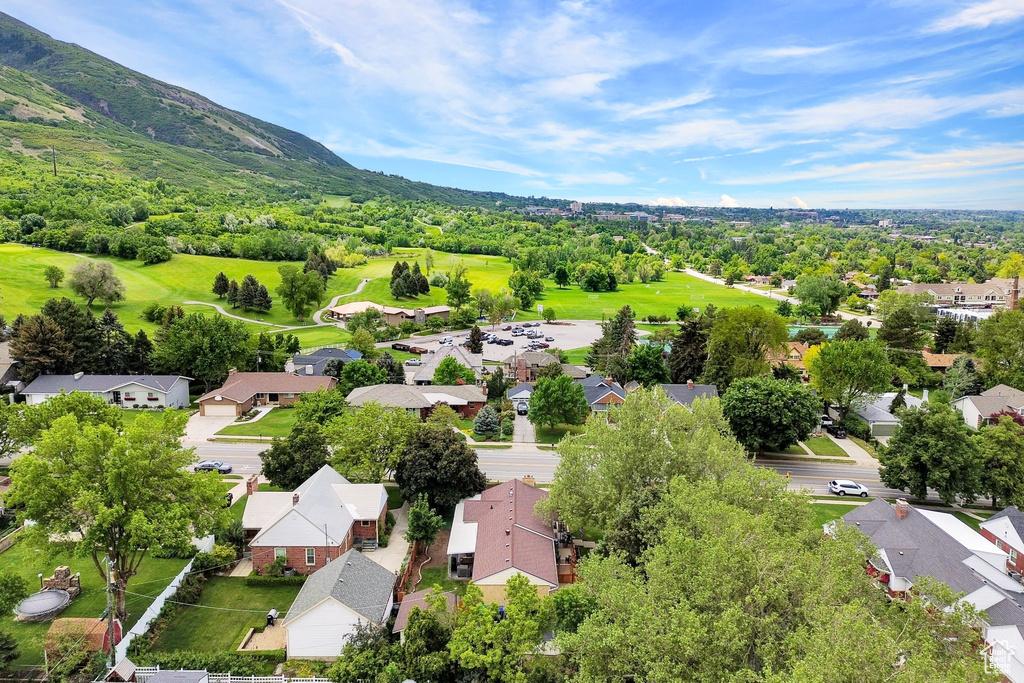 Aerial view of residential area with a mountainous background and a local golf course