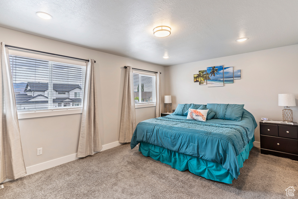 Carpeted bedroom with baseboards, a textured ceiling, and recessed lighting