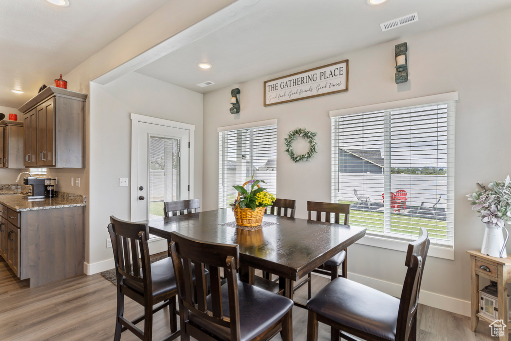 Dining area featuring baseboards, light wood-style floors, and recessed lighting