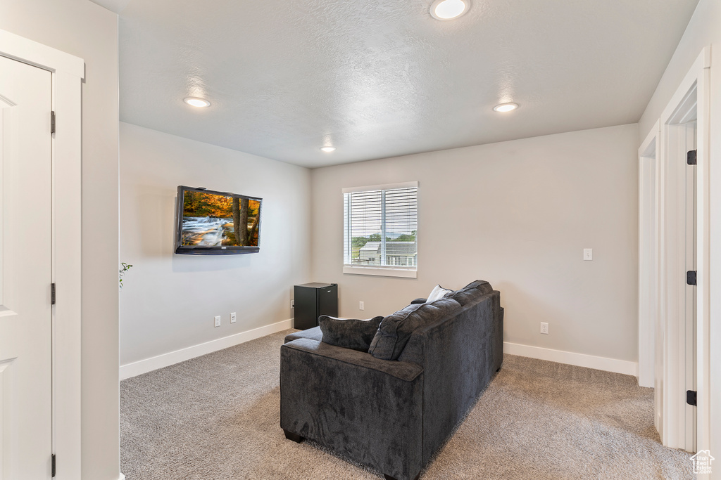 Living area featuring light carpet, baseboards, and recessed lighting