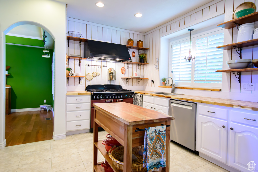Kitchen featuring open shelves, butcher block counters, stainless steel dishwasher, a sink, and recessed lighting