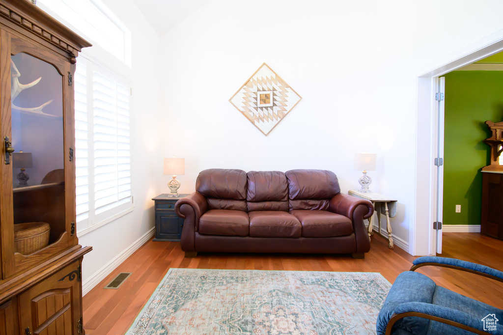 Living room featuring healthy amount of natural light, wood finished floors, and baseboards
