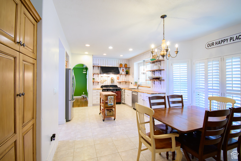 Dining space with a chandelier, recessed lighting, light tile patterned floors, and baseboards