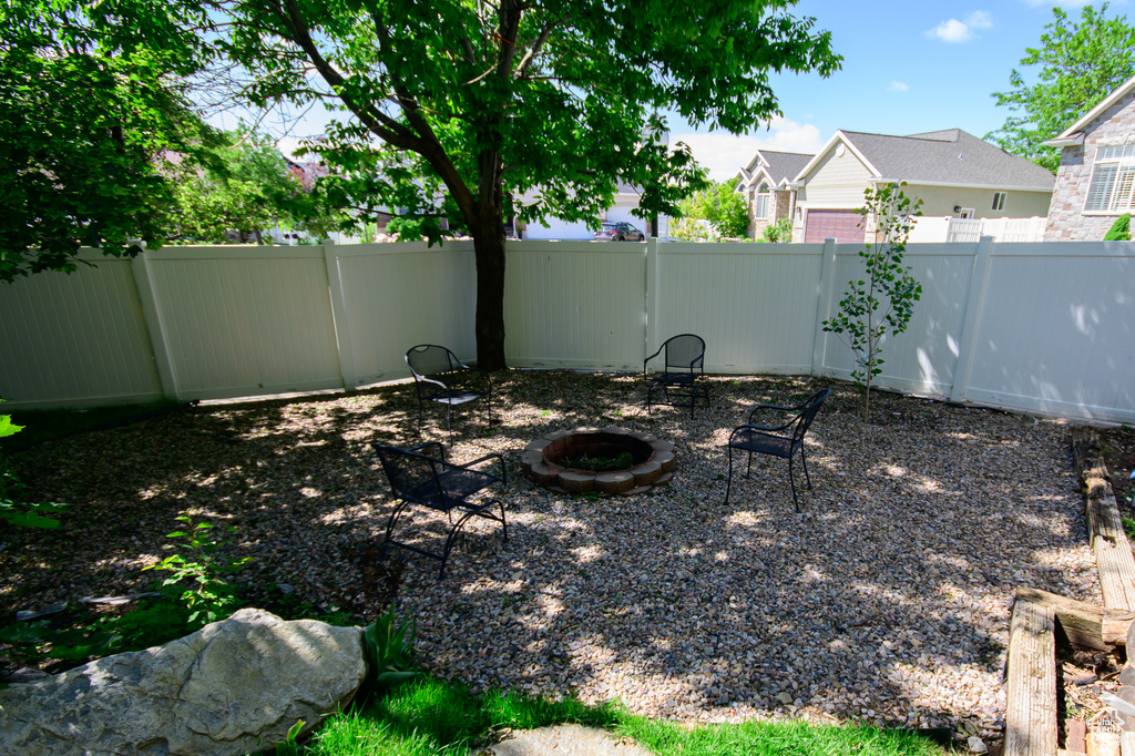 Fenced backyard featuring an outdoor fire pit