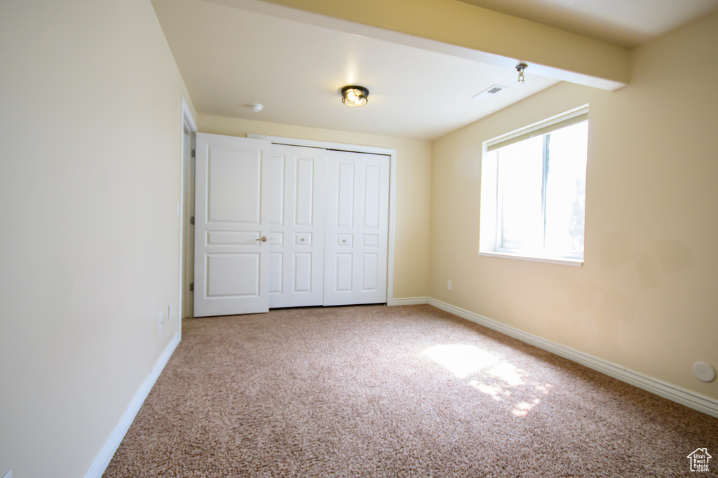 Unfurnished bedroom with carpet floors, baseboards, and a closet