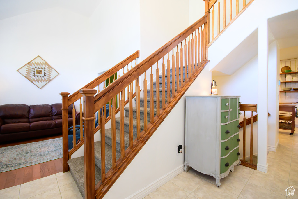 Staircase featuring tile patterned flooring and baseboards