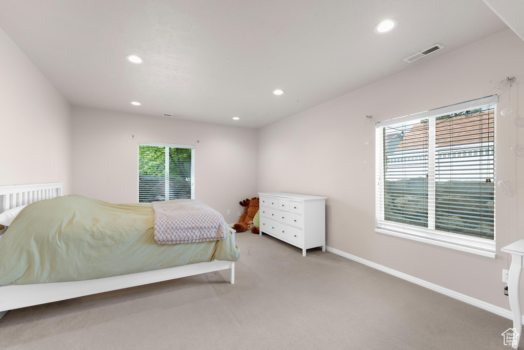 Bedroom with light carpet, recessed lighting, and baseboards