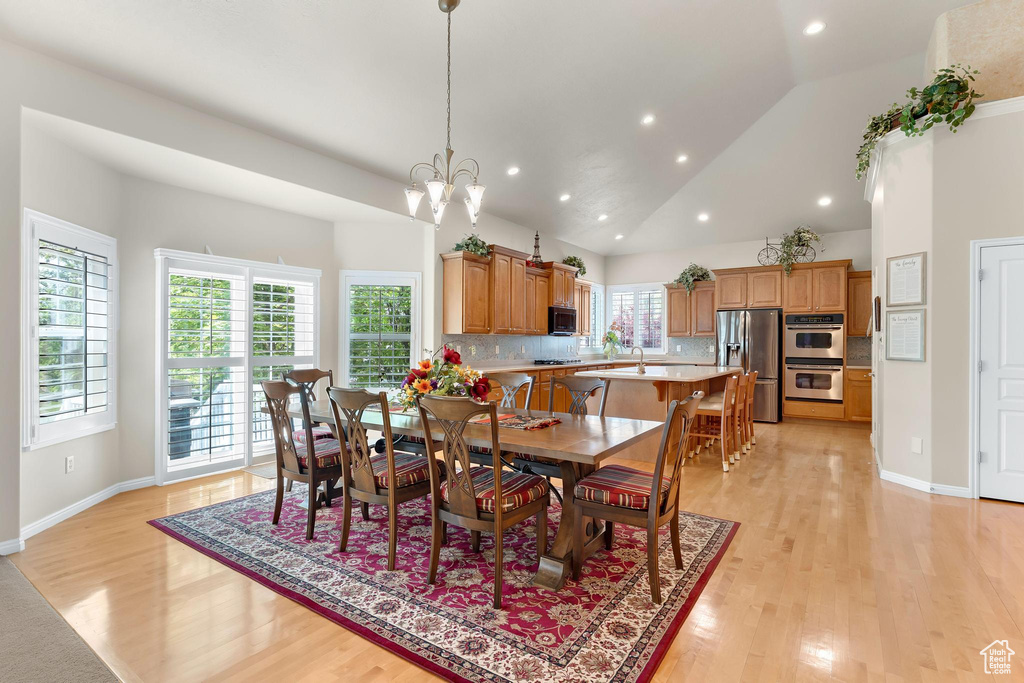Dining room featuring light wood-style floors, recessed lighting, a chandelier, baseboards, and vaulted ceiling