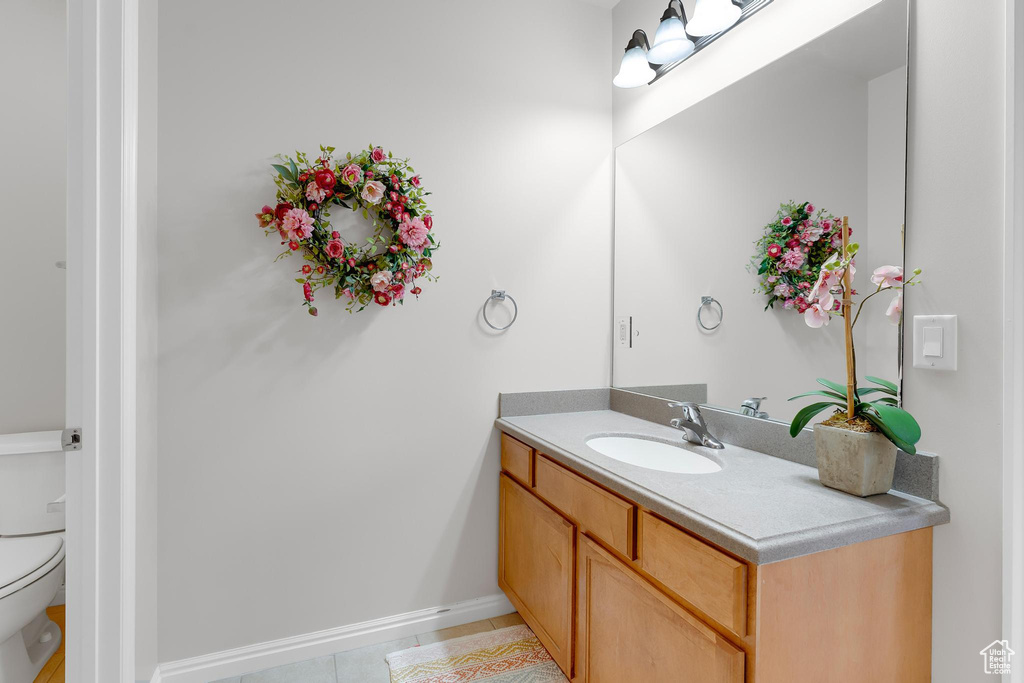 Bathroom with vanity, tile patterned flooring, toilet, and baseboards