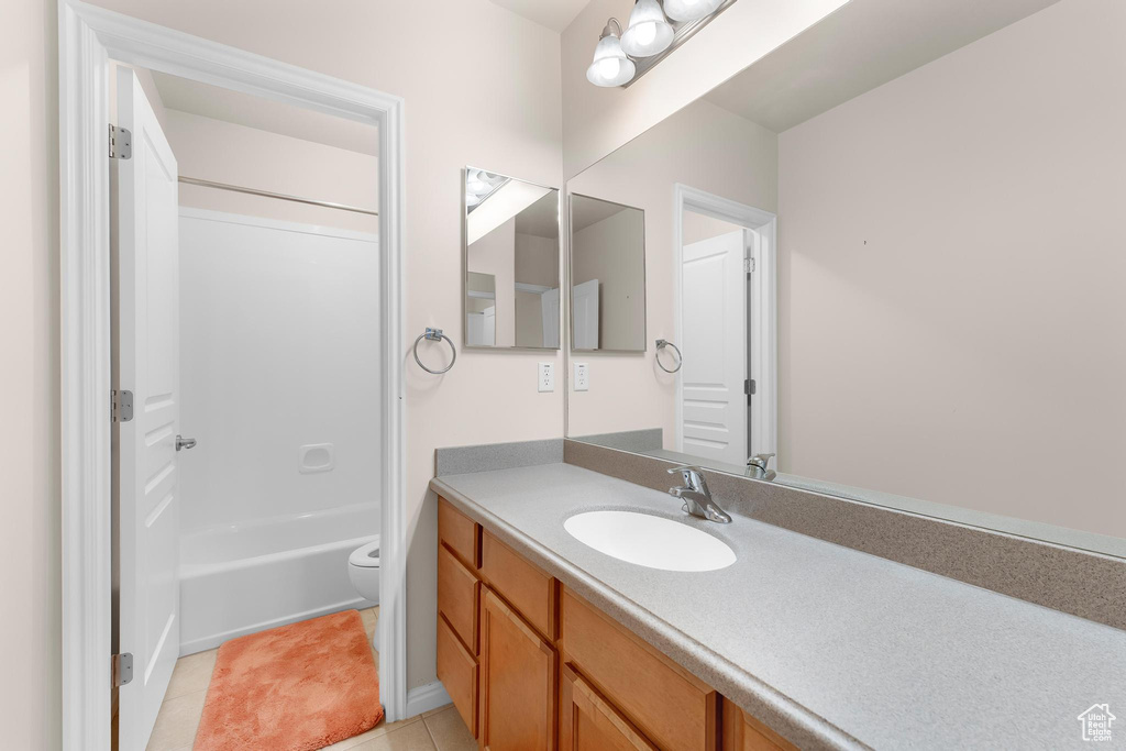 Bathroom with vanity, tile patterned flooring, toilet, and bathing tub / shower combination