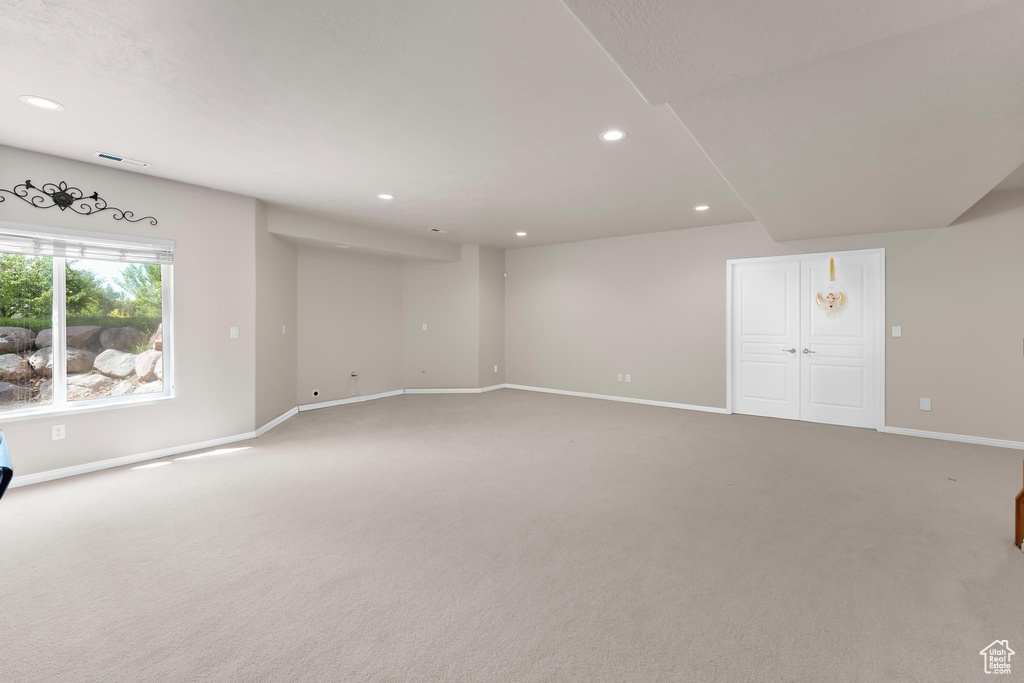 Unfurnished room featuring light carpet, baseboards, and recessed lighting