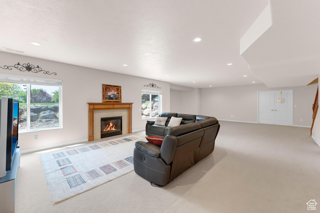 Living area featuring light colored carpet, recessed lighting, healthy amount of natural light, and a tile fireplace