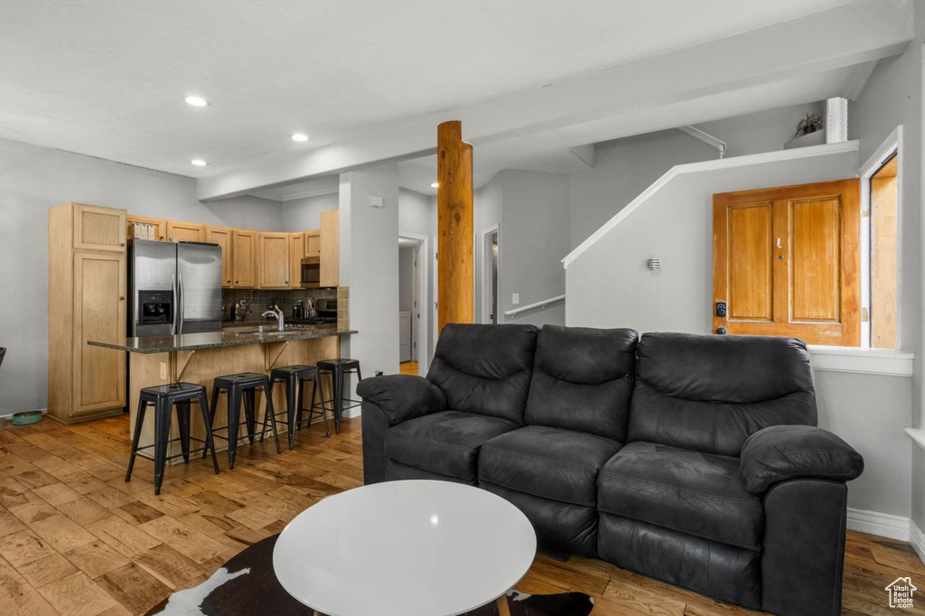 Living room featuring light wood-type flooring, recessed lighting, stairs, and baseboards