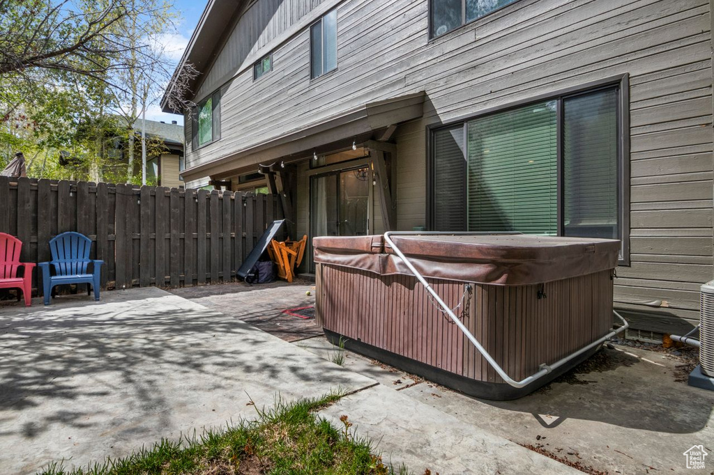 View of patio featuring a hot tub and fence
