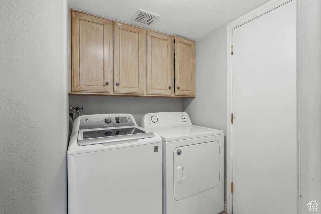 Laundry room with washer and clothes dryer and cabinet space