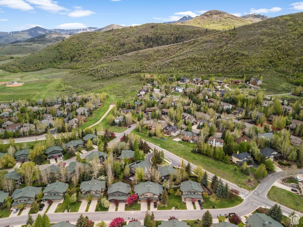 Aerial overview of property\'s location featuring nearby suburban area and a mountain backdrop