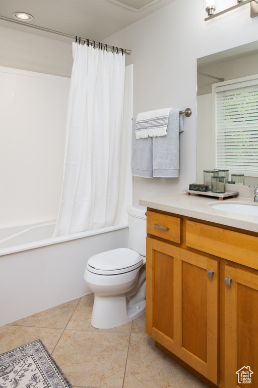 Full bath featuring toilet, tile patterned floors, shower / bath combination with curtain, and vanity