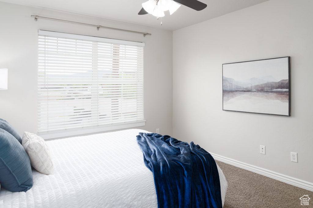 Carpeted bedroom with baseboards and ceiling fan