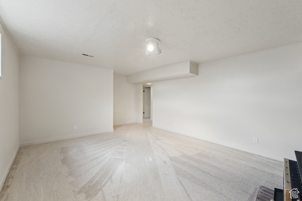 Spare room featuring light carpet and baseboards