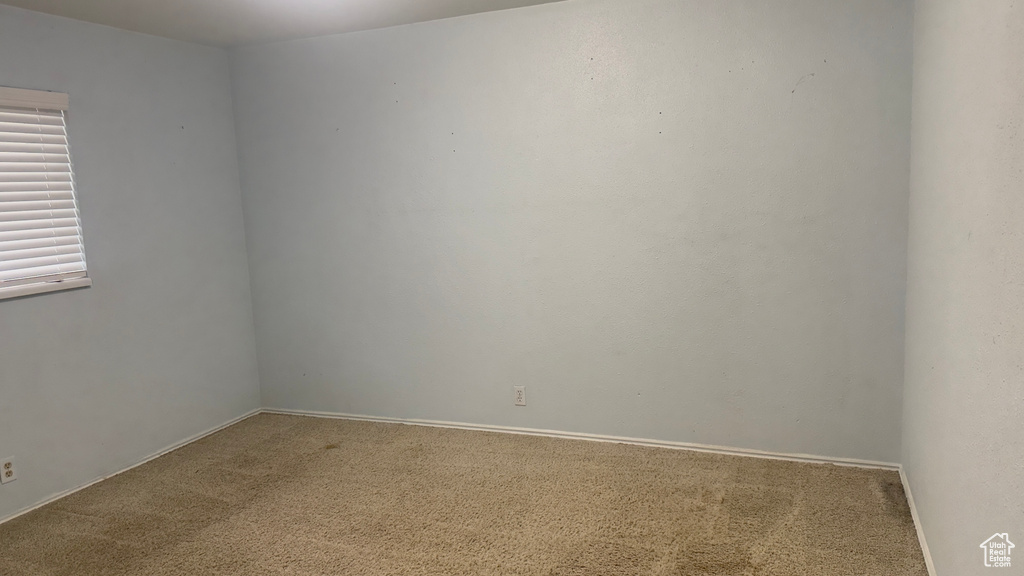 Empty room featuring carpet and baseboards
