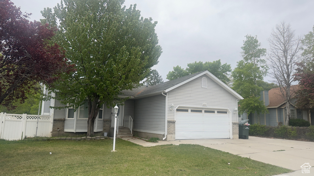 Ranch-style home featuring a garage and driveway