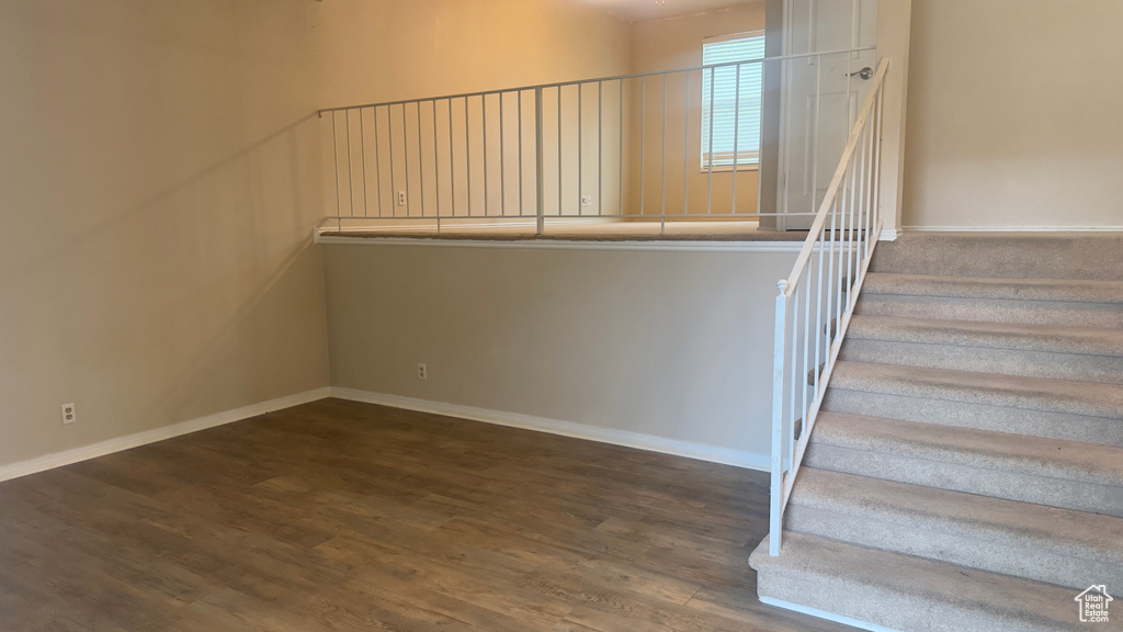 Stairway with wood finished floors and baseboards