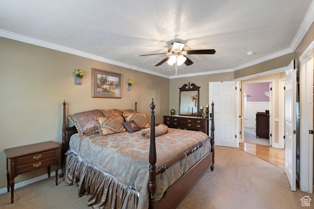 Bedroom with light carpet, crown molding, baseboards, and a ceiling fan