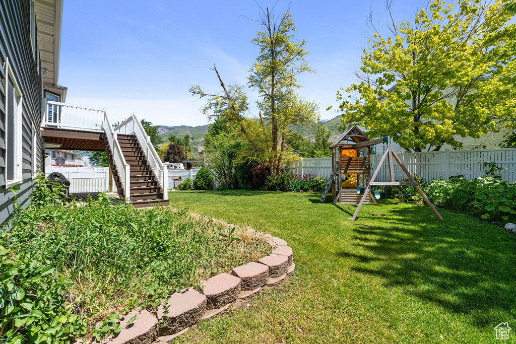 View of yard with a playground, stairs, and a deck with mountain view