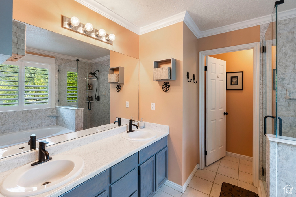 Full bathroom featuring a shower stall, tile patterned floors, a bath, double vanity, and crown molding