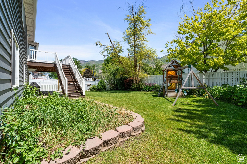 View of yard featuring a playground, stairs, and a mountain view