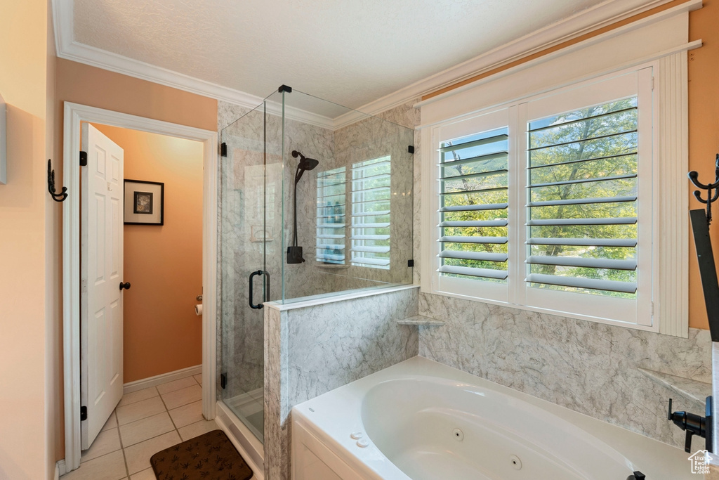 Bathroom featuring a shower stall, a jetted tub, crown molding, and tile patterned floors